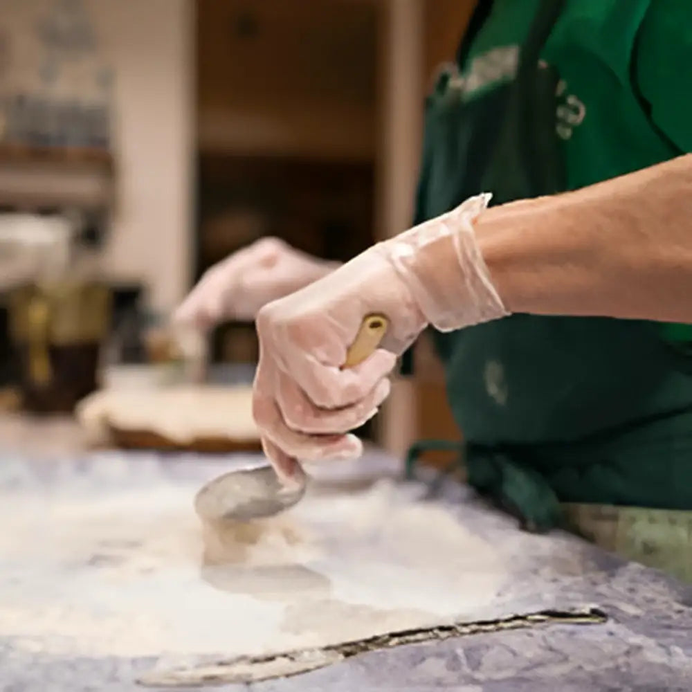 Person kneading dough while wearing Diamond Clear 4 mil Vinyl Powder Free Gloves